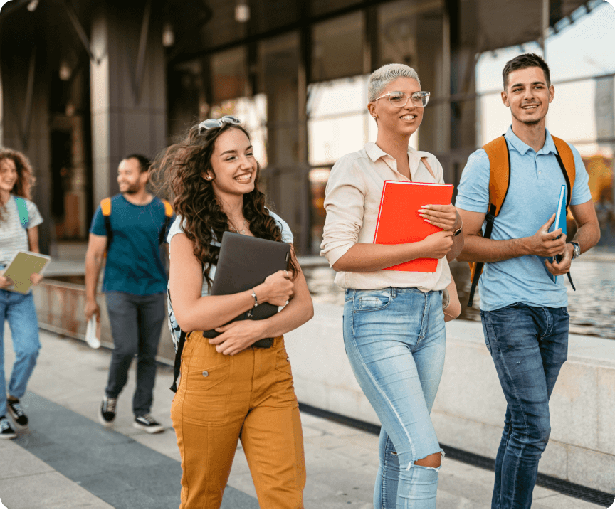 A group of international students walking outside through the campus of an educational institution