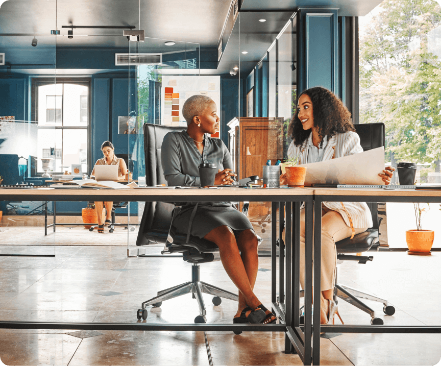 Two women sitting at a conference table in a business office
