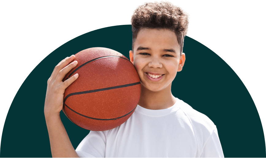 A smiling child holding a basketball